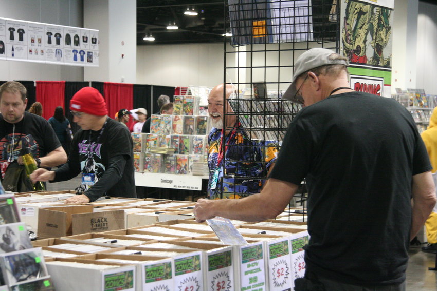 Though this year the name changed to Denver Pop Culture Con, comics are still the keystone of the annual event. As day two gets underway, early shoppers at one of the many comic vendors search out new books for their collections.